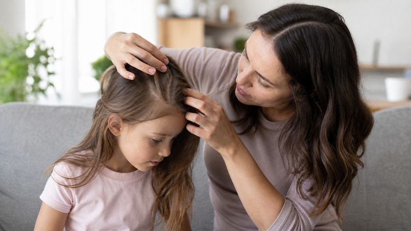 Madre revisando el pelo de su hijo buscando piojos